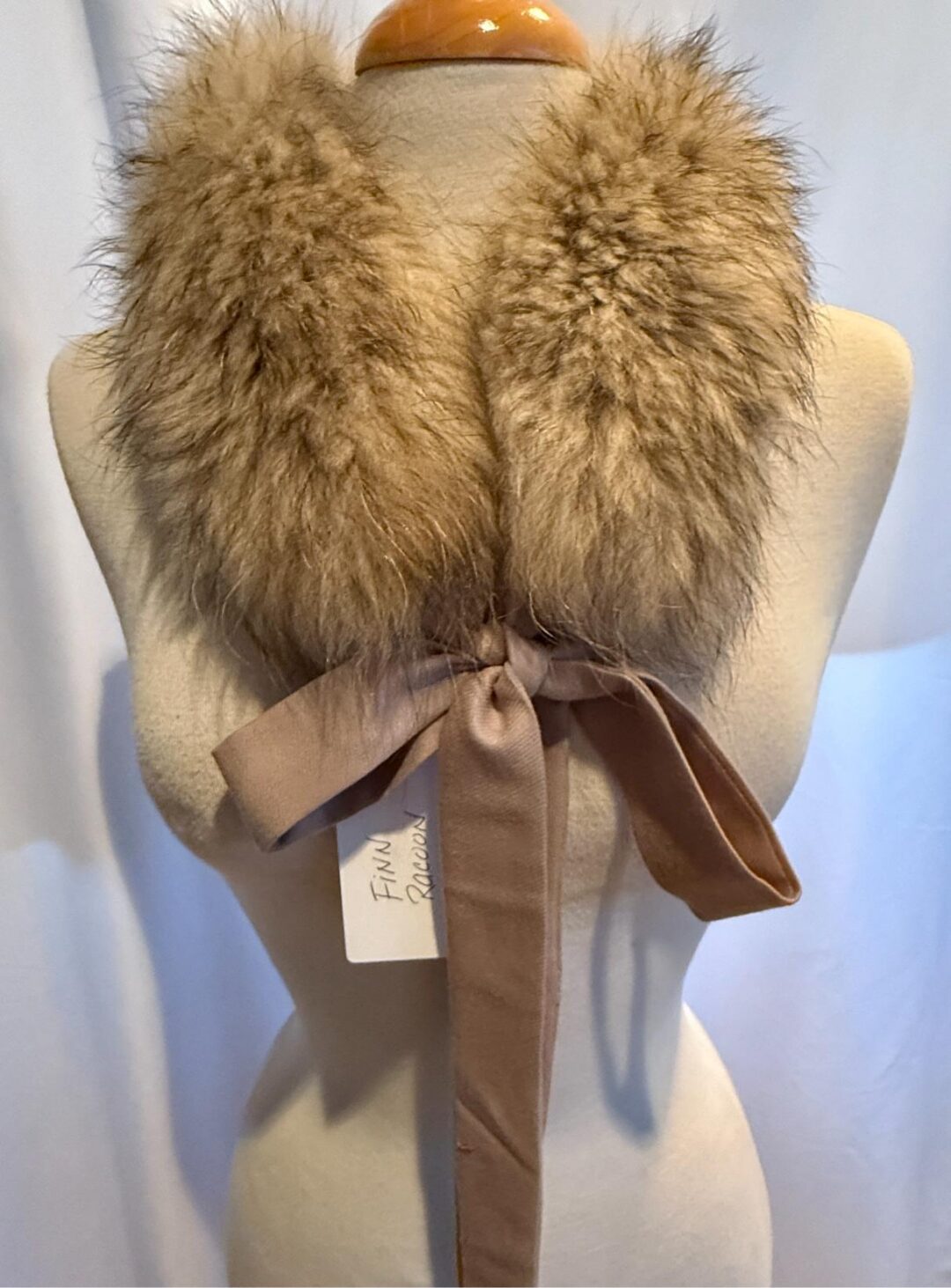 Tan fur collar with bow on mannequin