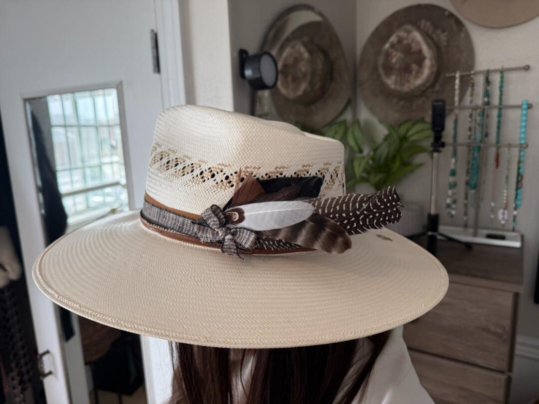 Wide-brim straw hat with feather decoration