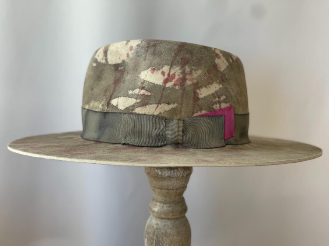 Patterned wide-brim fedora on wooden stand